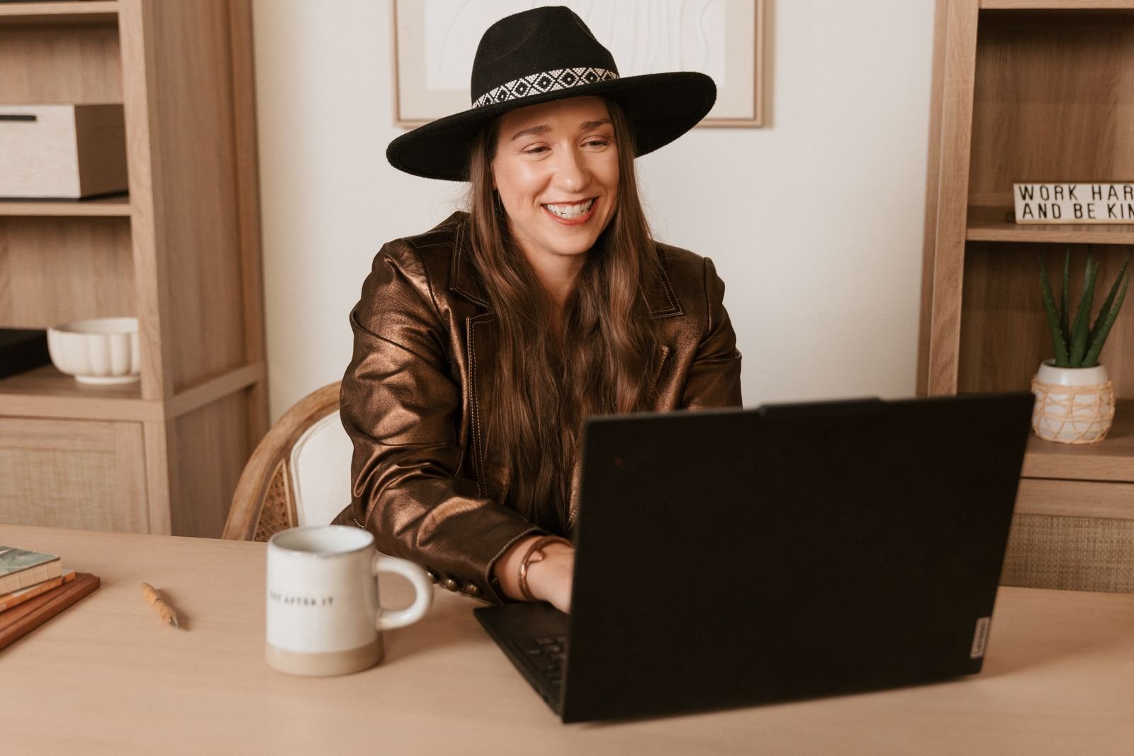 Kristin Winstanley, CPA, smiling while working on her laptop at her desk