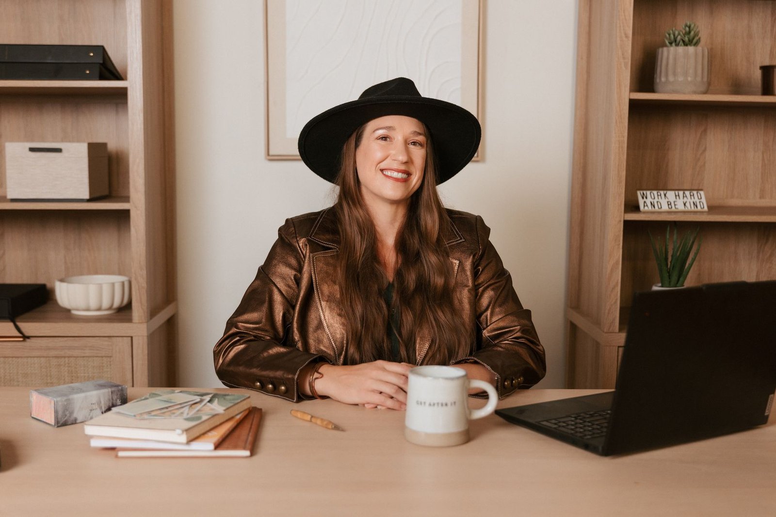Kristin Winstanley, CPA, smiling at her desk with her laptop and coffee mug
