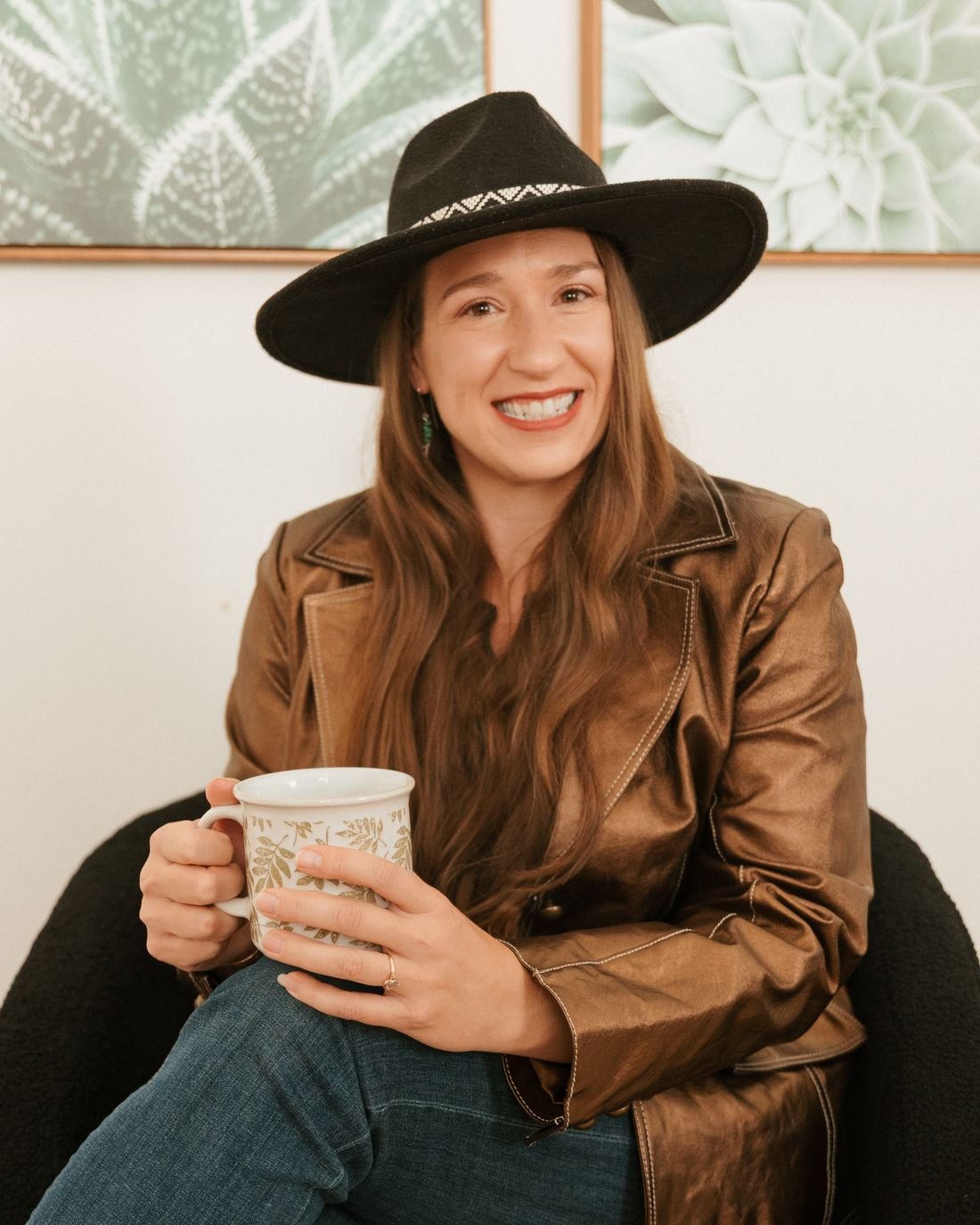 Kristin Winstanley smiling in an armchair, holding a coffee mug