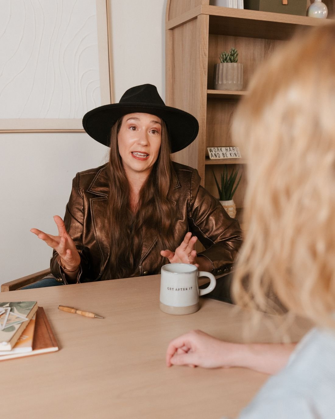 Kristin Winstanley, CPA, talking through numbers with a business owner at her desk